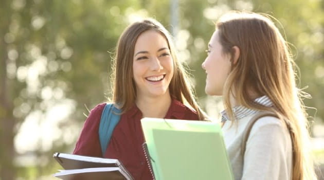 Two young female students talking to each other