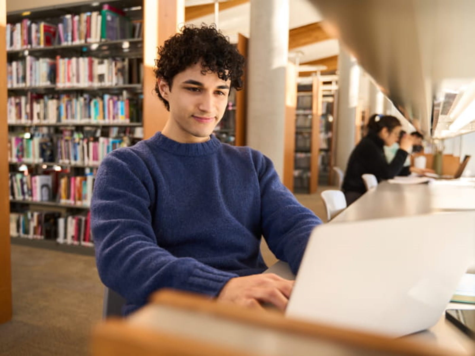Boy on laptop in library 