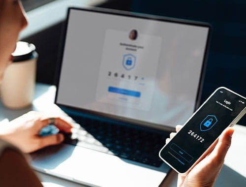 Woman holding and looking at a smart phone and laptop technology cyber security