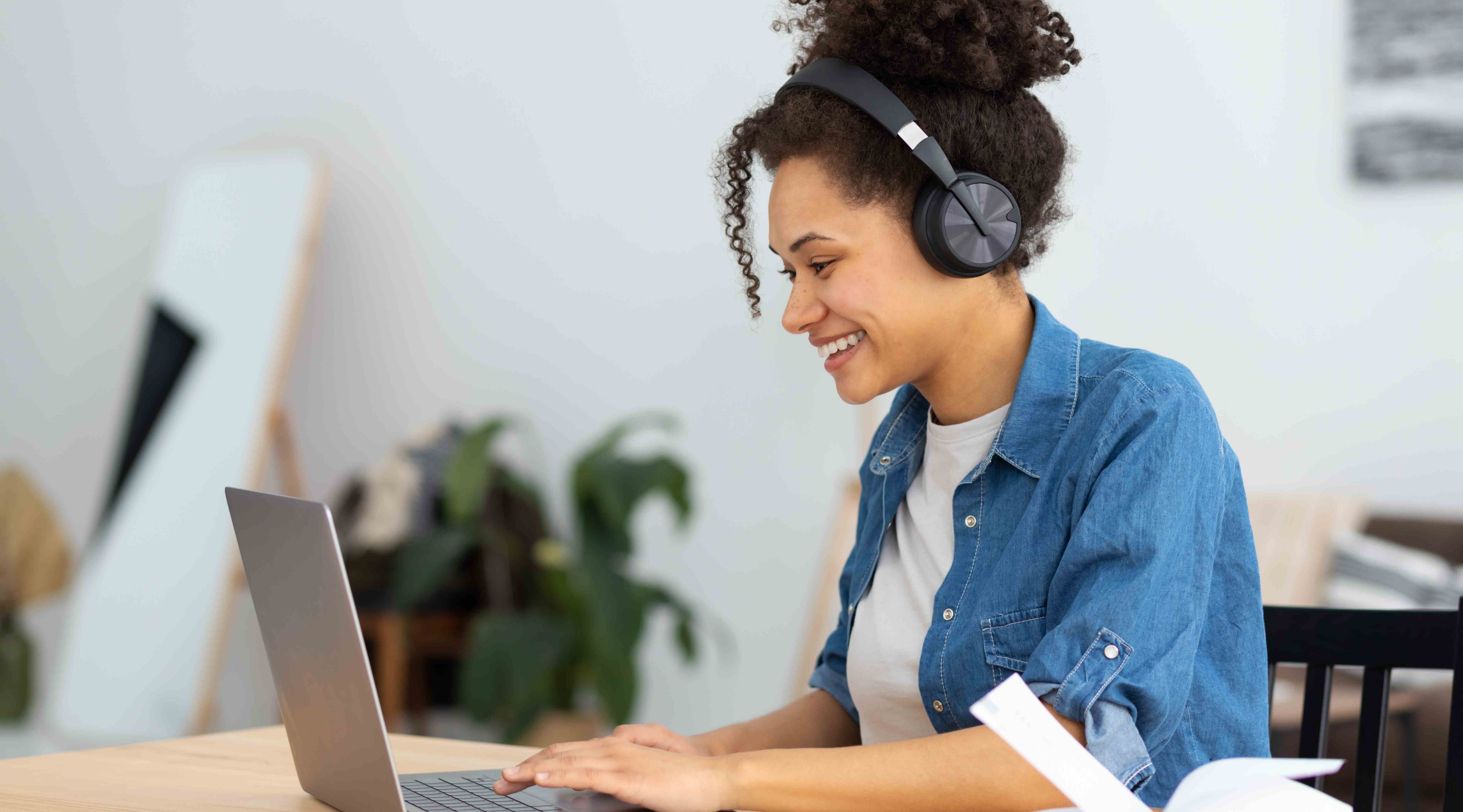 Woman with laptop open and headphones. 