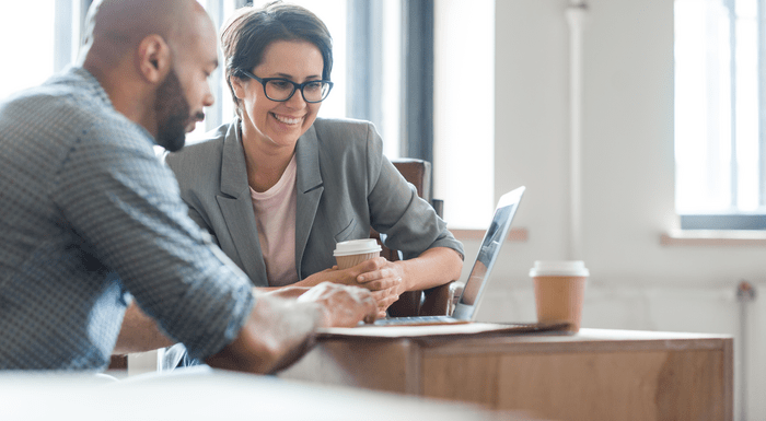 Professionals looking at laptop together